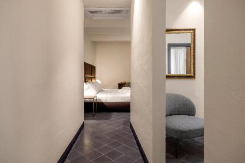 a hallway with a chair and a bedroom at LOCANDA SANTAMARINA Dimora di Charme in Palermo