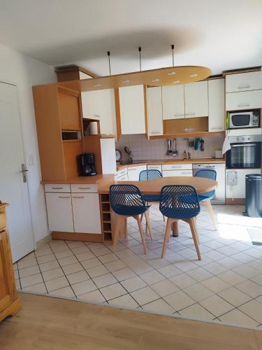 une cuisine avec une table et des chaises dans l'établissement Maison de la fontaine, à Saint-Méloir-des-Ondes