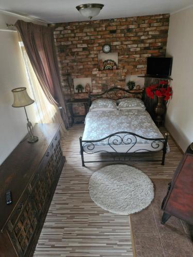 a bedroom with a bed and a brick wall at Pas Ligita in Biržai
