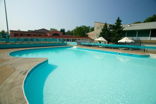 a large swimming pool with blue water in front of a building at Brennan Beach Lakeview Park Model 1 in Pulaski
