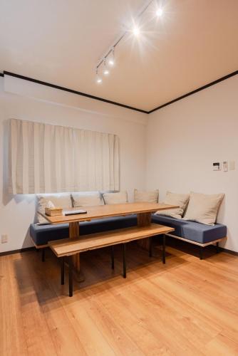 a living room with two benches and a couch at Shima Yadori in Oshima