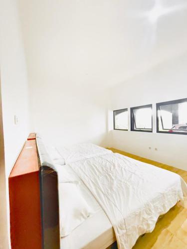 a bedroom with a bed with white sheets at Villa Situ Citiwu Ciwidey in Ciwidey