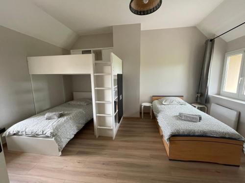 une chambre avec deux lits et un lit superposé dans l'établissement Lovely Normandy Charmante maison de campagne, à La Bigne