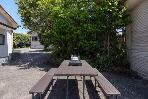 a wooden picnic table sitting outside of a house at Shima Yadori in Oshima