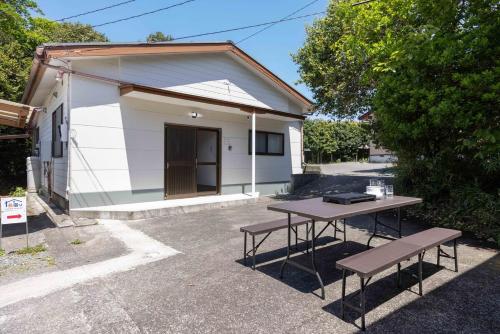a table with two benches in front of a building at Shima Yadori in Oshima