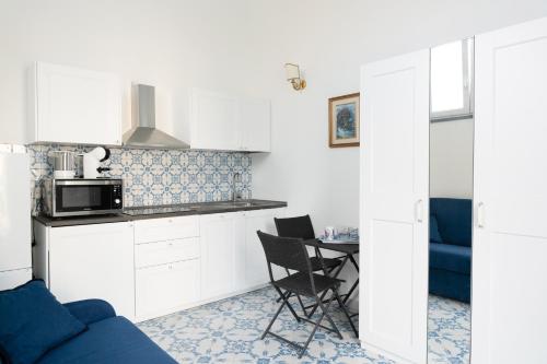 Una cocina con un sofá y una mesa con microondas. en Villa Alba - Smeraldo, en Amalfi