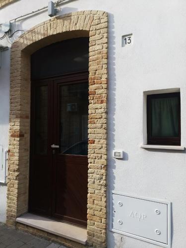 a brown door on a building with a brick wall at La Casa di MaGioLò in Serracapriola