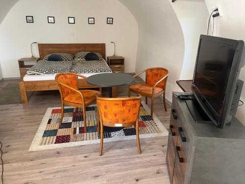 a room with a table and chairs and a bed at Penzion Marcipánka in Třeboň