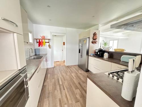 une cuisine avec des armoires blanches et un réfrigérateur en acier inoxydable dans l'établissement gîte, à Six-Fours-les-Plages