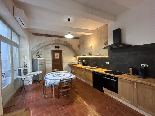 une cuisine avec une table au milieu dans l'établissement La Comtoise, à Thèzan-lès-Béziers