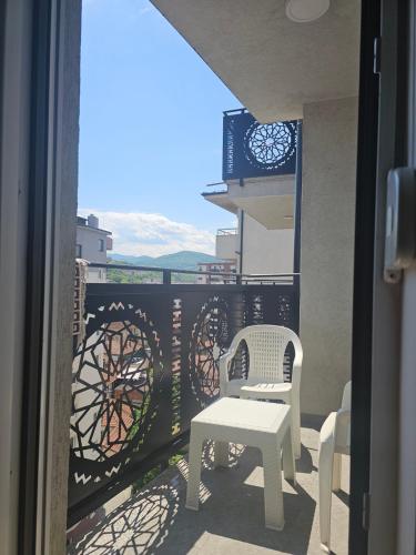a balcony with a table and chairs and a clock at Izo Apart in Novi Pazar