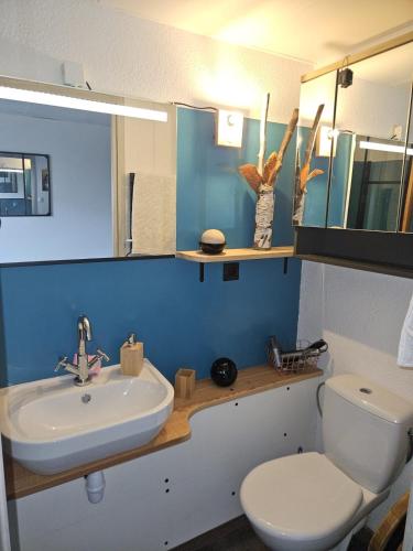 une salle de bain avec des toilettes blanches et un lavabo dans l'établissement Le Petit Coolmar, à Colmar