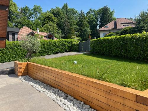 d'un jardin avec un mur de séparation et une pelouse. dans l'établissement Villa avec piscine à 5 minutes du lac, à Annecy