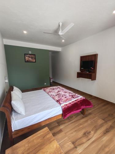 a bedroom with a bed and a flat screen tv at Moon Valley, kanthalloor in Kanthalloor