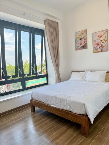 a bedroom with a bed and a large window at Hi Homestay - Near Kitesurfing My Hoa in Phan Rang