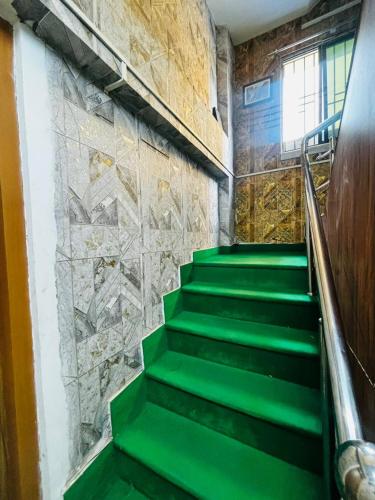 a green staircase in a building with a stone wall at Panama & Panama Hotel and Restaurant in New Town