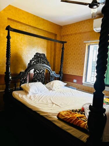 a bedroom with a large bed with a black frame at Panama & Panama Hotel and Restaurant in New Town