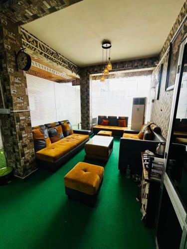 a living room with couches and a green floor at Panama & Panama Hotel and Restaurant in New Town