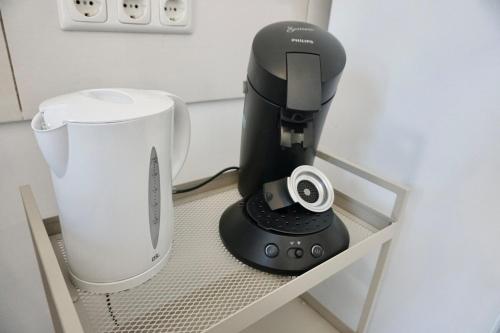 a black mixer sitting on a shelf next to a blender at NEU zentrale Wohnung Netflix Balkon 4 Gäste in Andernach