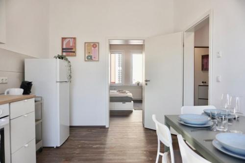 a white kitchen with a table and a refrigerator at NEU zentrale Wohnung Netflix Balkon 4 Gäste in Andernach