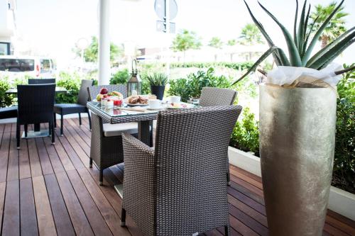 a patio with a table and chairs on a deck at Hotel Ca' Bianca in Riccione