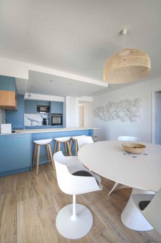 - une cuisine avec une table et des chaises blanches dans l'établissement Pépite de Thau, Marseillan-port, France, à Marseillan