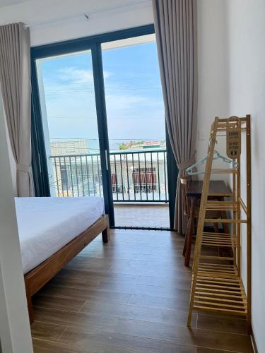 a bedroom with a bed and a ladder and a balcony at Hi Homestay - Near Kitesurfing My Hoa in Phan Rang