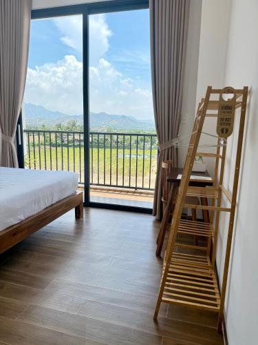 a bedroom with a ladder and a bed and a balcony at Hi Homestay - Near Kitesurfing My Hoa in Phan Rang
