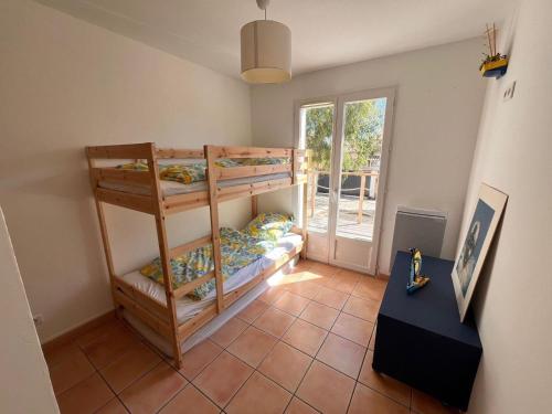 une chambre avec trois lits superposés et une fenêtre dans l'établissement Villa Argelia - Piscine - 10 couchages, à Lapalme