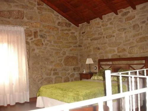 a bedroom with a bed and a stone wall at Casita curbeiros in O Grove