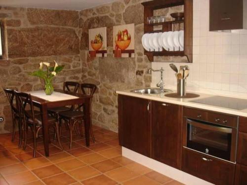 a kitchen with a table and a sink and a counter at Casita curbeiros in O Grove