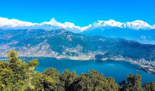 a view of a lake with snow capped mountains at Homestay and Trip Organiser in Bākhri Kharka