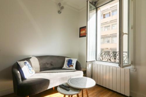 un salon avec un canapé et une fenêtre dans l'établissement Apartment for 2 in the 14th district Paris, à Paris