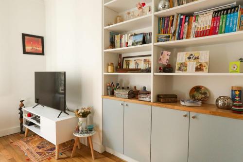 Cette chambre dispose d'un bureau, d'une télévision et de livres. dans l'établissement Apartment for 2 in the 14th district Paris, à Paris
