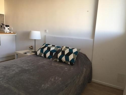 une chambre avec un lit avec deux oreillers dessus dans l'établissement Studio lumineux avec terrasse à Carnon-Plage, à Mauguio