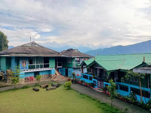 a group of buildings with mountains in the background at Kewzing Makhim Homestay in Sosing