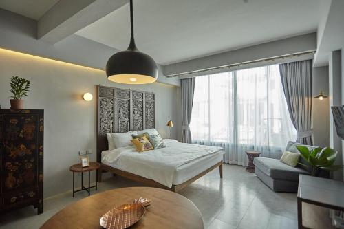 a bedroom with a bed and a couch and a table at Stylish Studio in Prime Sukhumvit-Next to BTS Nana in Bangkok