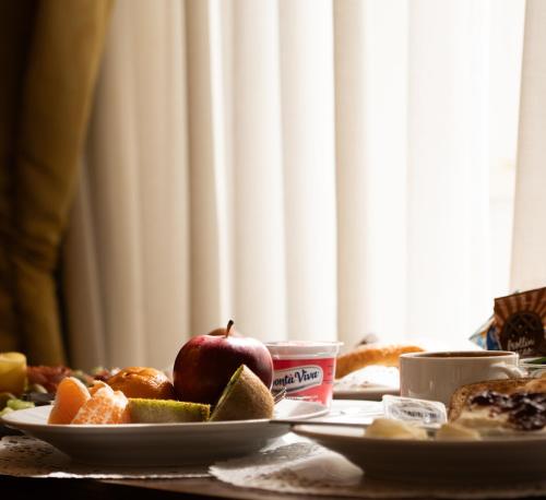 a table with a plate of fruit and bread at Hotel Miami in Rome