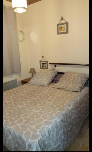 a bedroom with a large bed and a nightstand with a bed sidx sidx sidx at Les Lauriers Roses in Salavas