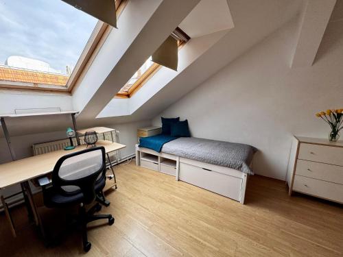 une chambre mansardée avec un lit et un bureau et un bureau dans l'établissement 120 m2 apartment in the centre of the old town, à Bratislava