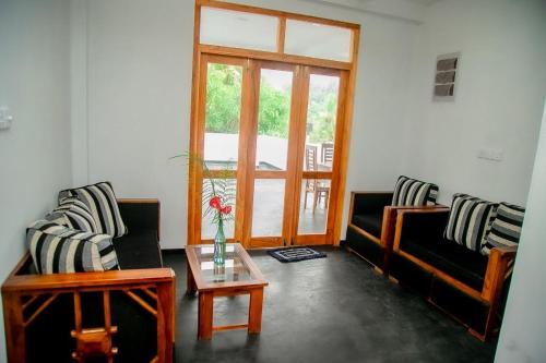 a living room with two couches and a coffee table at Casa Lashmika in Hikkaduwa
