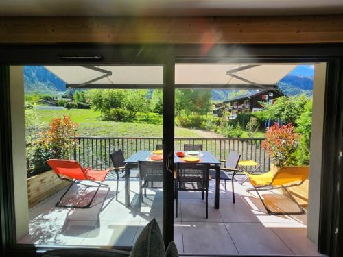 un patio avec une table et des chaises sur une terrasse dans l'établissement La Yaute Chamonix-Les Houches, aux Houches