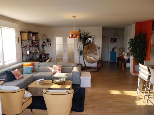 un salon avec un canapé et une table dans l'établissement Beau T4 de 95 m2 avec terrasse sur Anglet, à Anglet