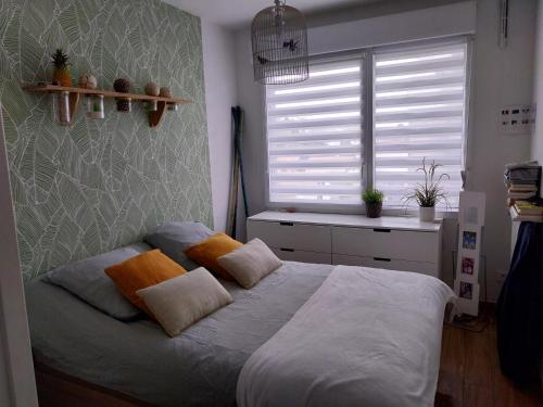 une chambre avec un lit avec des oreillers et une fenêtre dans l'établissement Beau T4 de 95 m2 avec terrasse sur Anglet, à Anglet