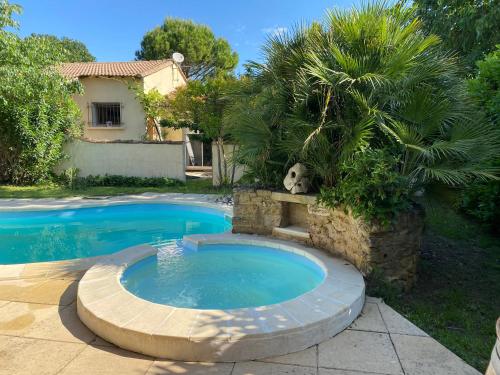 - une piscine dans une cour avec un chien assis à côté dans l'établissement Sun flower House, à Collias