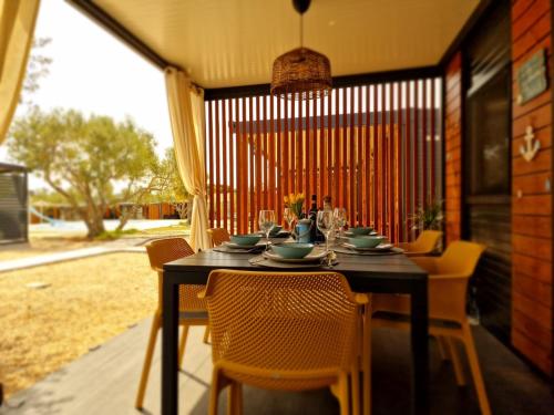 a dining room table with chairs and a black table and chairsktop at Vi&No Mobile Home - Camping Pirovac in Pirovac