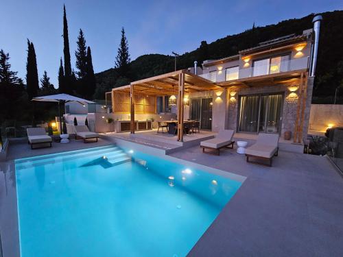 a house with a swimming pool in front of a house at Villa Aenya in Yenion