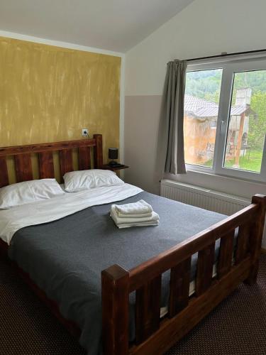 a bedroom with a bed with two towels on it at Cabanute Luca Ama Bran in Bran