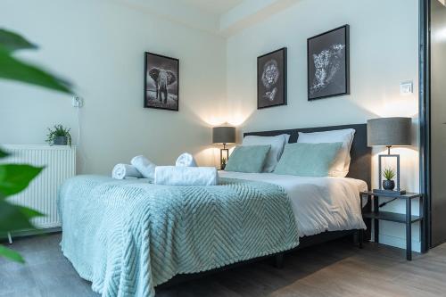 a bedroom with a bed with a blue blanket and two lamps at Modern Stay with Wi-Fi - Tilburg in Tilburg