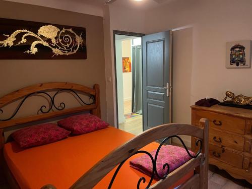 - une chambre avec un lit orange et une commode en bois dans l'établissement Villa dans la forêt provençale, à Jouques